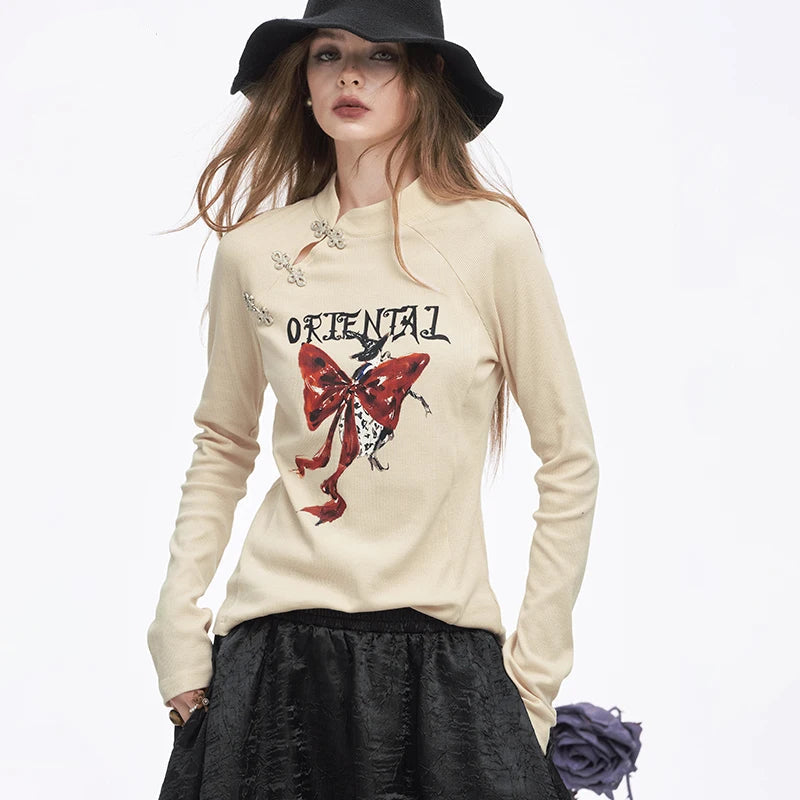 ELFSACK 2025 Winter New Arrivals Y2K Chinese Style Irregular Button Collar Bow Graphic Long Sleeve Tshirt For Women